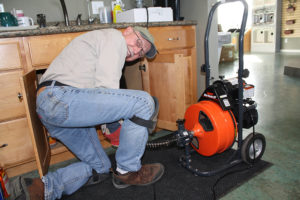 Plumber from Red Bud Plumbing using Mini-Rooter XP power drain cleaner
